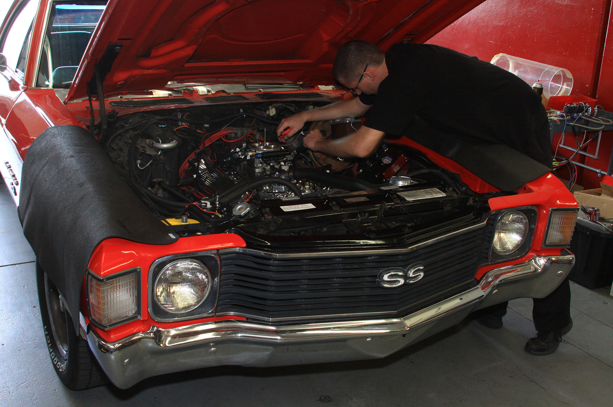  Car buyer inspecting a 1966 Chevelle SS engine bay before purchase